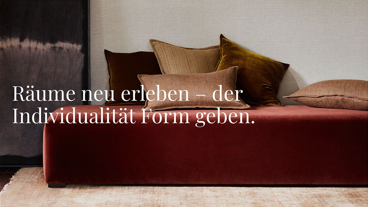 Sofa mit dunkelrotem Bezug und einigen Kissen